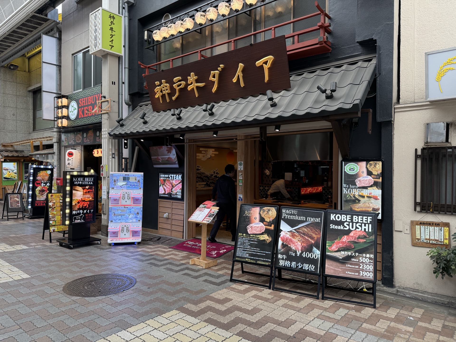 商店街の飲食店前に設置されたクレーンゲームの実写写真